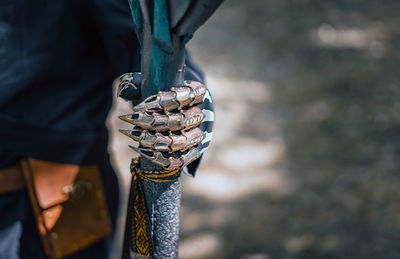 Midsection of warrior holding weapon outdoors