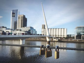 Padlocks on railing against puente de la mujer bridge