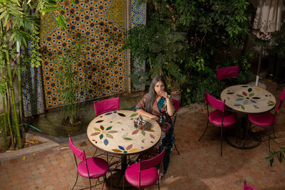 Woman sitting on chair against table