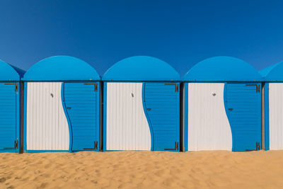 Scenic view of colored beach cabins at the beach in dunkirk, france against blue summer sky