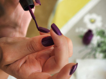 Midsection of woman holding purple flower