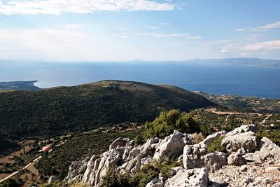 Scenic view of mountains by sea against sky