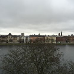 Buildings in city against cloudy sky