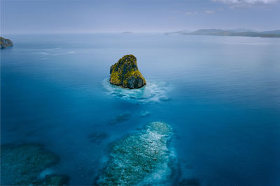 Scenic view of rock in sea against sky