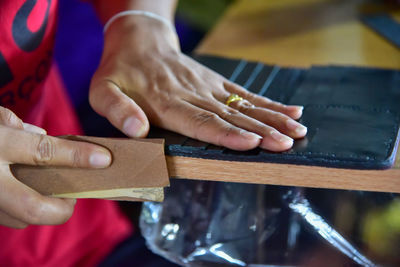 Midsection of woman working over leather on table