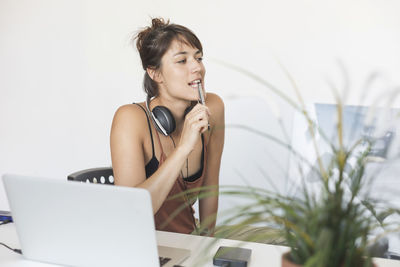 Young woman using laptop while sitting on table