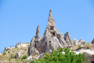 Low angle view of rock formation against clear blue sky