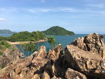 Scenic view of rocks by sea against sky