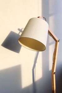 Close-up of electric lamp on table against wall