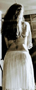 Rear view of woman standing against wall