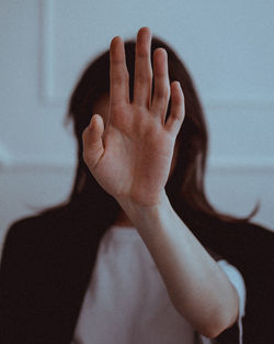 Close-up of woman covering face with hand