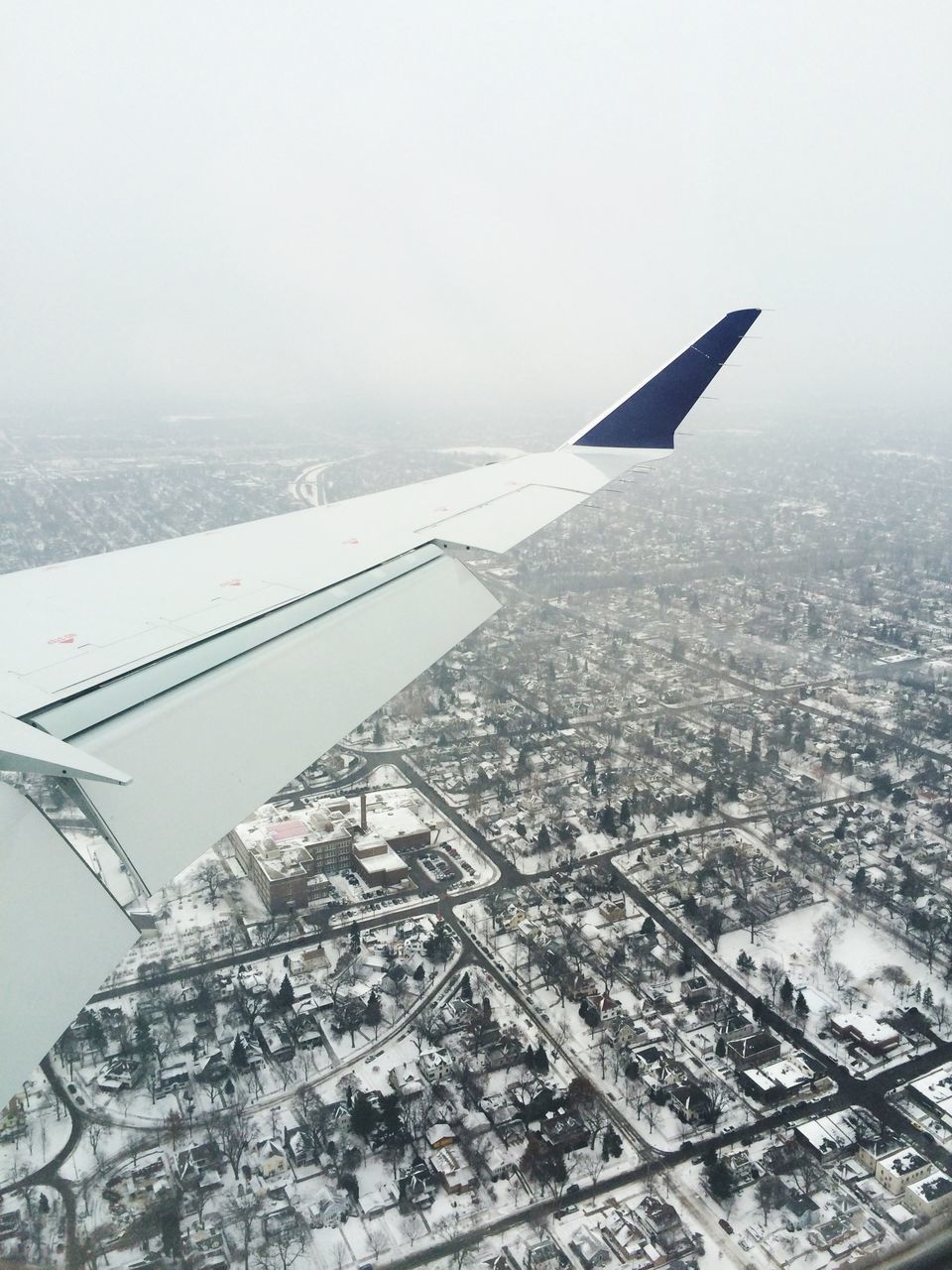 airplane, air vehicle, aircraft wing, flying, transportation, aerial view, mode of transport, part of, cropped, mid-air, clear sky, travel, landscape, copy space, sky, public transportation, on the move, journey, cityscape, city