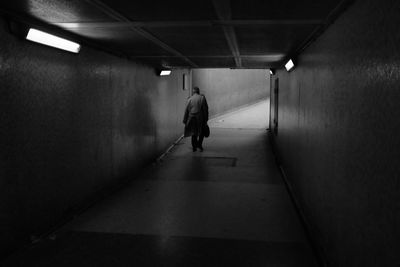 Rear view of man walking in corridor