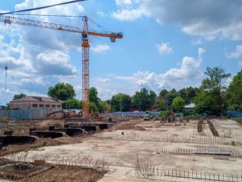 Cranes at construction site against sky