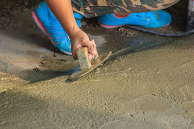 Low section of man relaxing on sand at beach