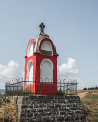 Red statue with cross on top