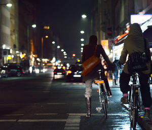 Rear view of women on bicycles at street