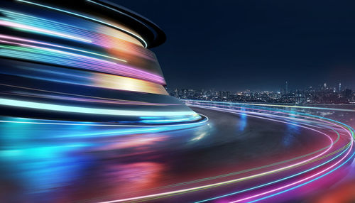 Light trails on road against sky at night