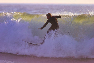 Full length of man splashing water in sea