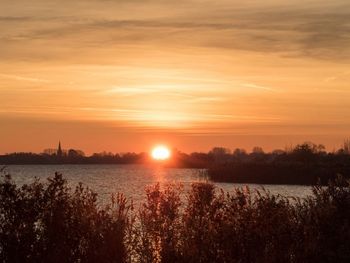 Scenic view of lake against orange sky