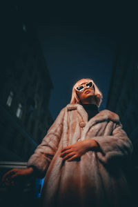 Low angle view of woman standing against wall