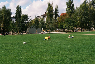 People on golf course against sky