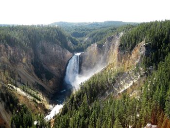 Scenic view of waterfall against sky