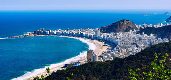 High angle view of sea and cityscape against sky