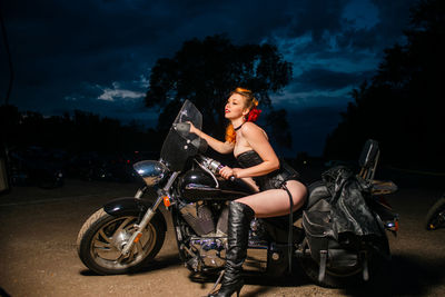 Woman riding motorcycle against sky