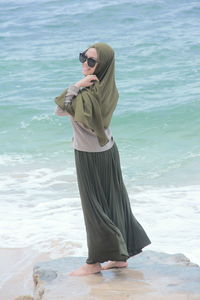 Woman wearing sunglasses standing on beach