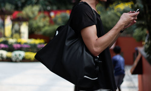 Midsection of man using phone