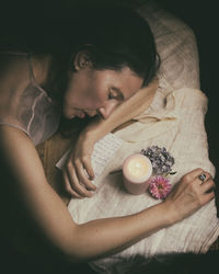 Woman lying face down next to a letter and some flowers ii