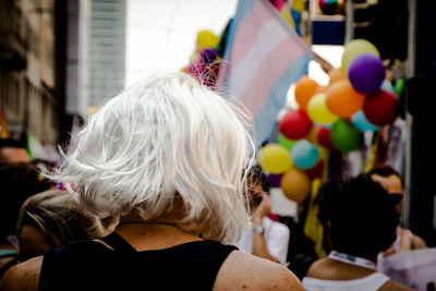 Rear view of woman against multi colored balloons and flag