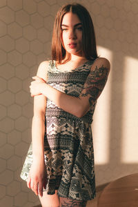 Portrait of beautiful woman standing against wall