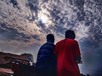 Rear view of people looking against sky