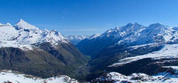 Scenic view of snowcapped mountains against clear sky