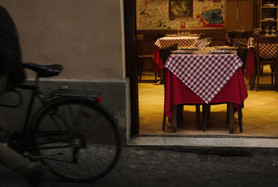 Empty chairs and tables in cafe against building