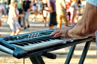 Cropped hands of man playing piano