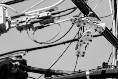 Low angle view of bicycle hanging against clear sky