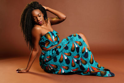 Young woman wearing mask against gray background