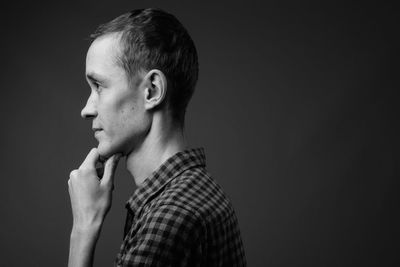 Portrait of boy looking away against black background