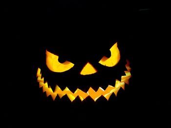 Close-up of illuminated pumpkin against black background