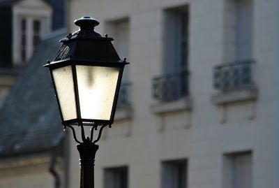 Close-up of illuminated street light against building