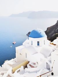 White building by sea against mountain