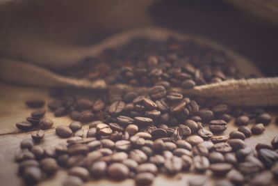 Close-up of roasted coffee beans scattered on table