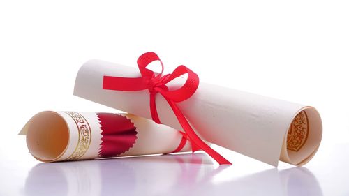 Close-up of paper tied to box against white background