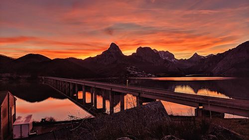 Bridge over lake against sky during sunset