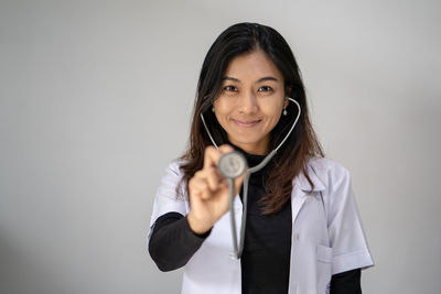 Portrait of smiling young woman against white background