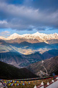 Scenic view of snowcapped mountains against cloudy sky