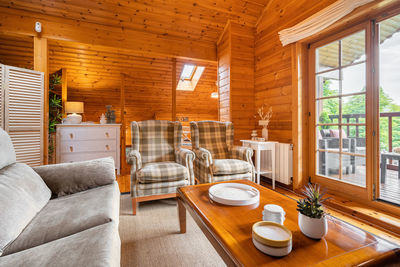 Cozy interior of a country house in a wooden design. living room with terrace and forest view